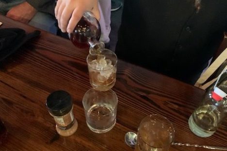 a person sitting at a table with wine glasses
