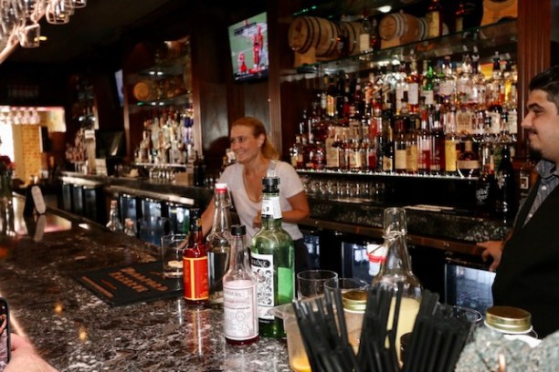a person sitting at a table with wine glasses