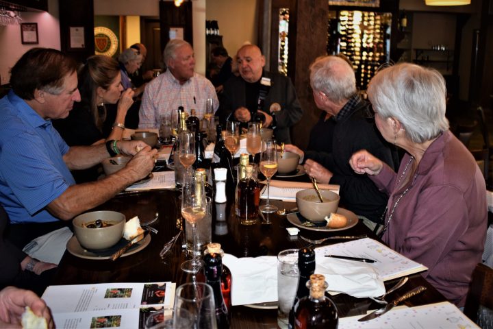 a group of people sitting at a table drinking wine
