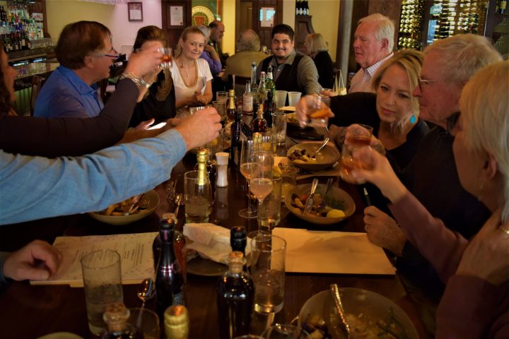 a group of people sitting at a table with wine glasses