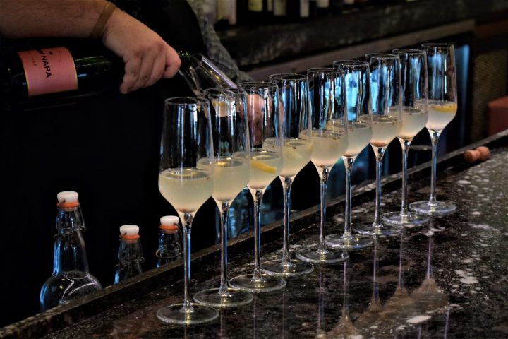 a person sitting at a table with wine glasses