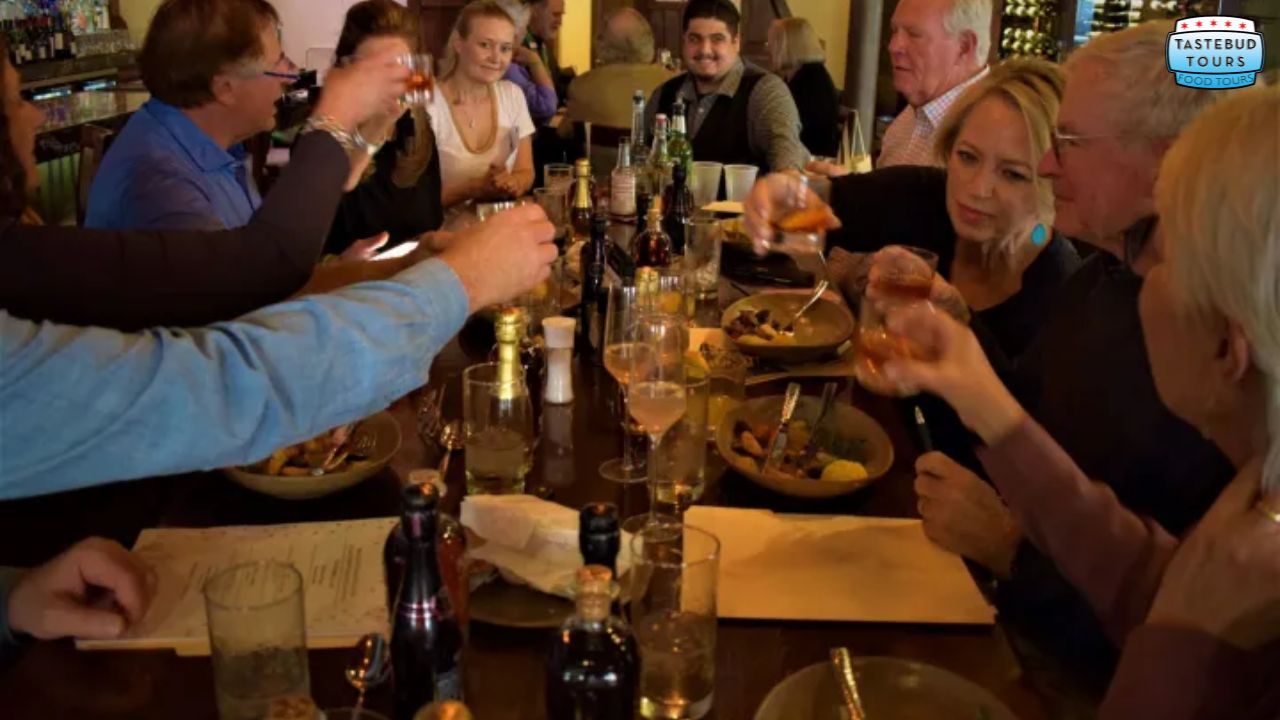 A group of people raising glasses in a toast at a restaurant table.
