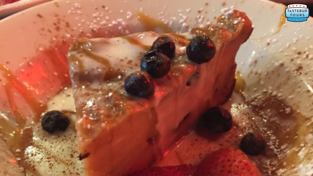 Slice of dessert with berries and caramel drizzle on a plate.