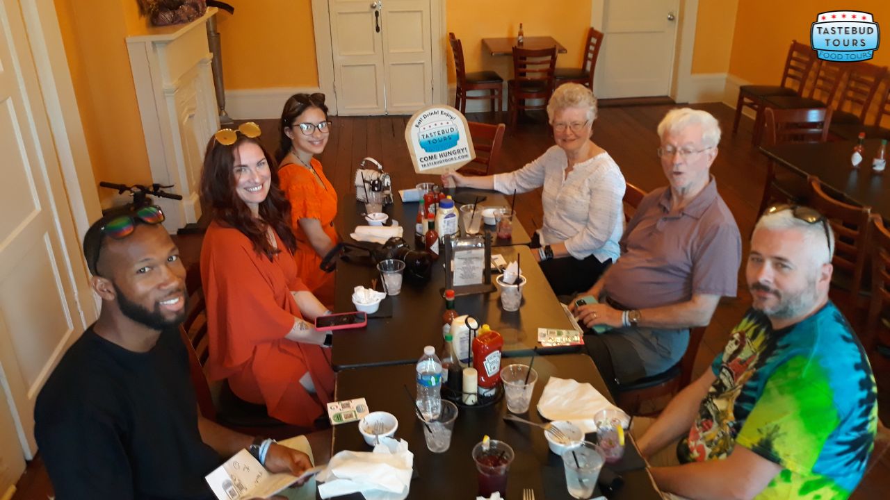 Group of seven people seated around a table in a restaurant.