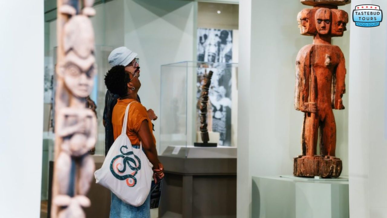 Two people admire sculptures in a museum exhibition.