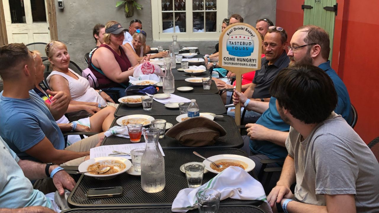 A group of people dining outdoors, engaged in conversation.