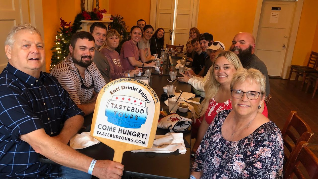 Visitors enjoying a meal in New Orleans during a food tour through Tastebud Tours.