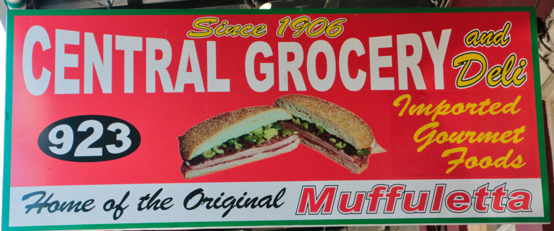 Red sign for Central Grocery and Deli, featuring a muffuletta sandwich image.