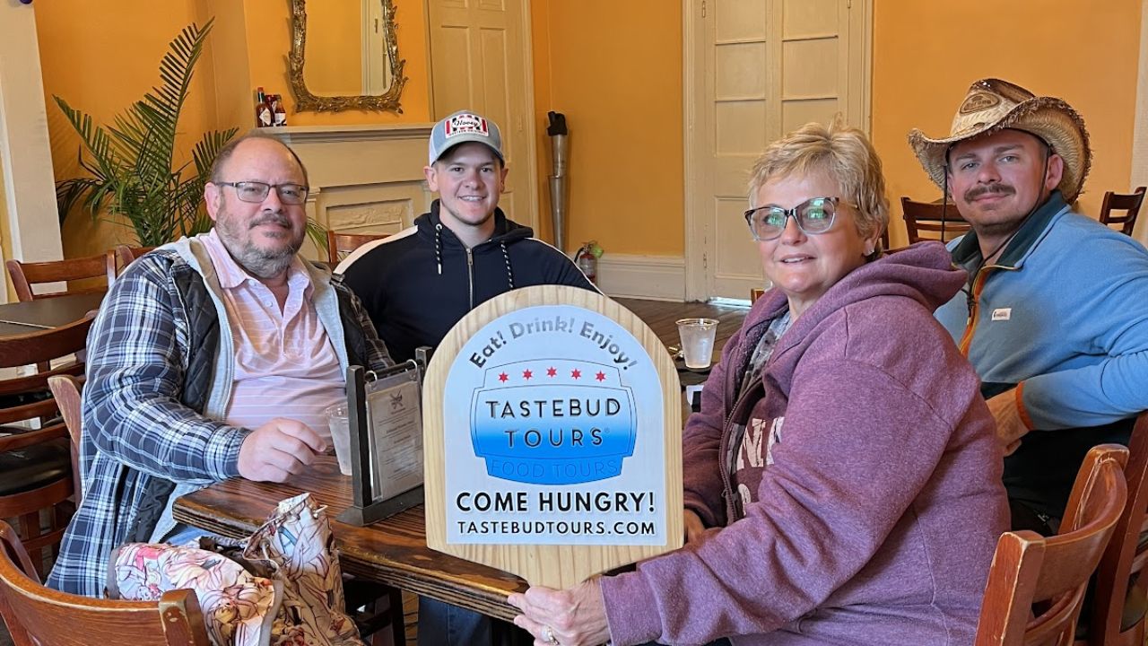 Visitors enjoying a New Orleans party inside a decorated restaurant on a food tour.