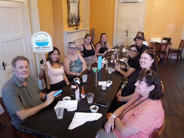 Group enjoying a Tastebud Tours food experience at a restaurant in New Orleans.