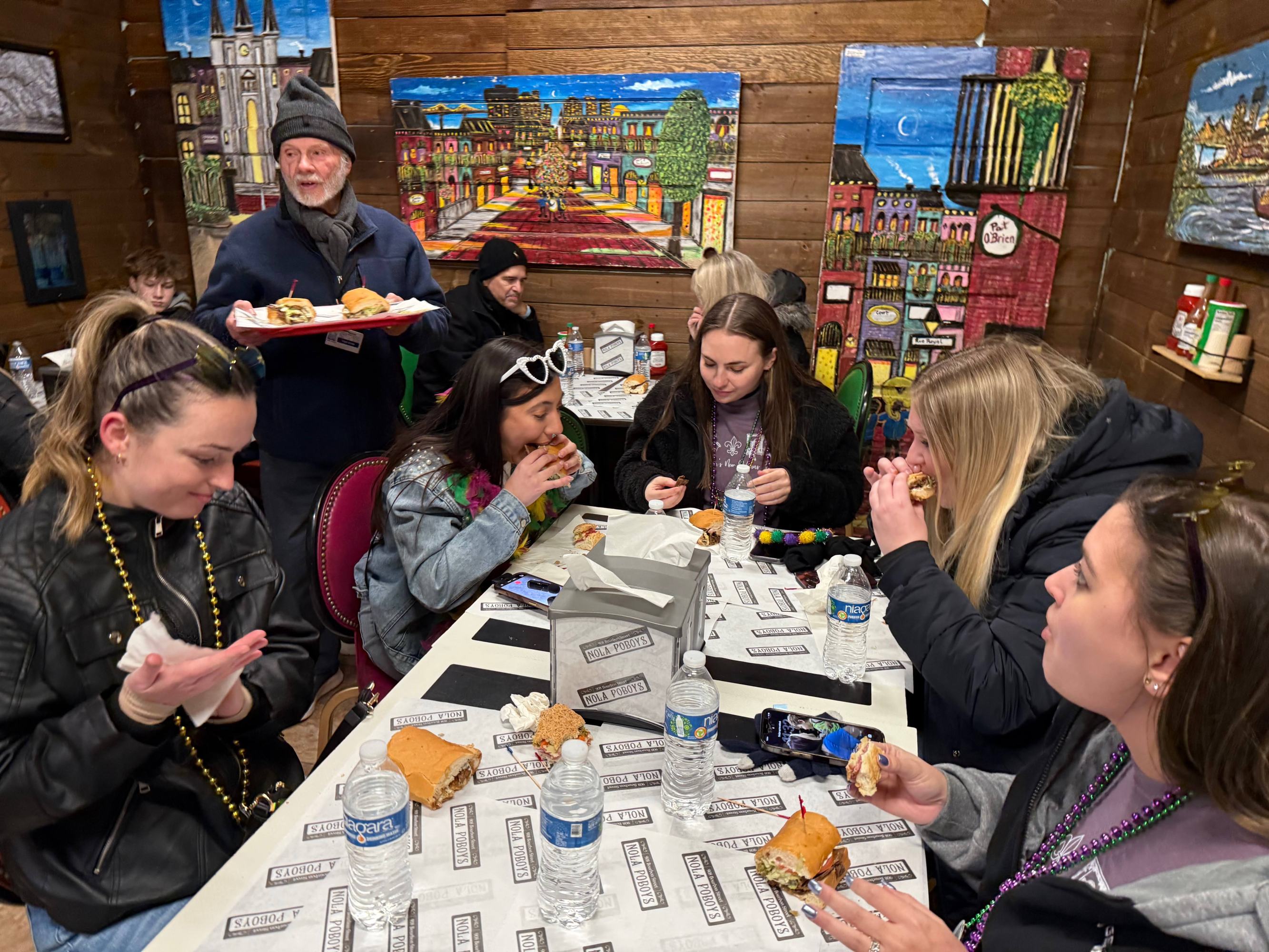 Po’boys being served to a small group of tourists during a New Orleans food tour.