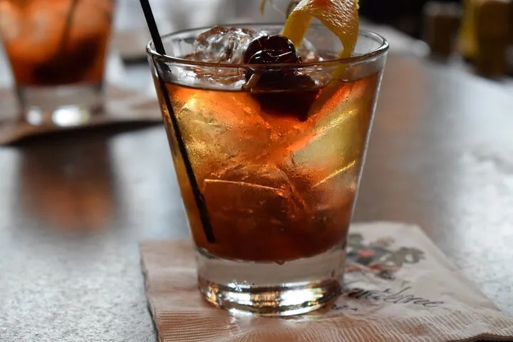 Classic whiskey cocktail garnished with a cherry and orange peel in New Orleans
