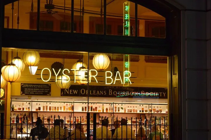 Oyster bar storefront in New Orleans lit up at night.