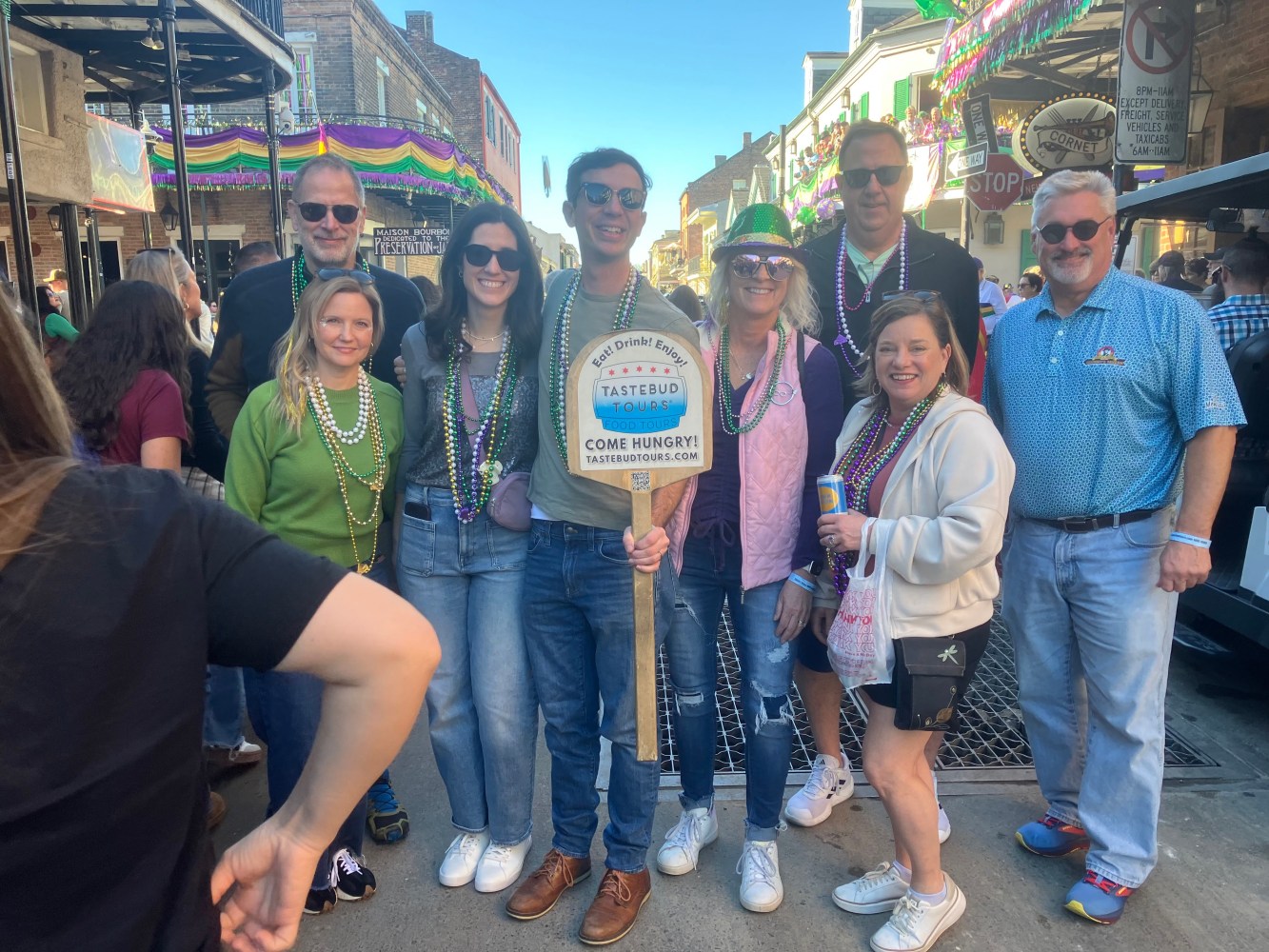 Tastebud Tours guests posing on a lively French Quarter street in New Orleans.