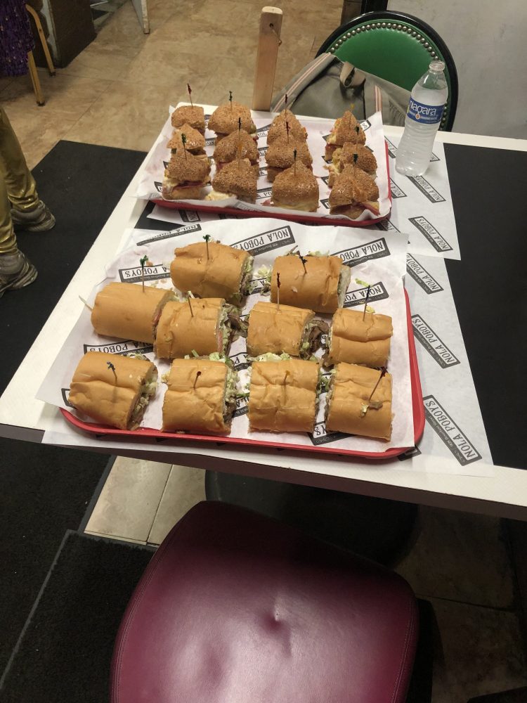 Trays of sliced New Orleans po-boy sandwiches prepared for guests on a guided food tour.