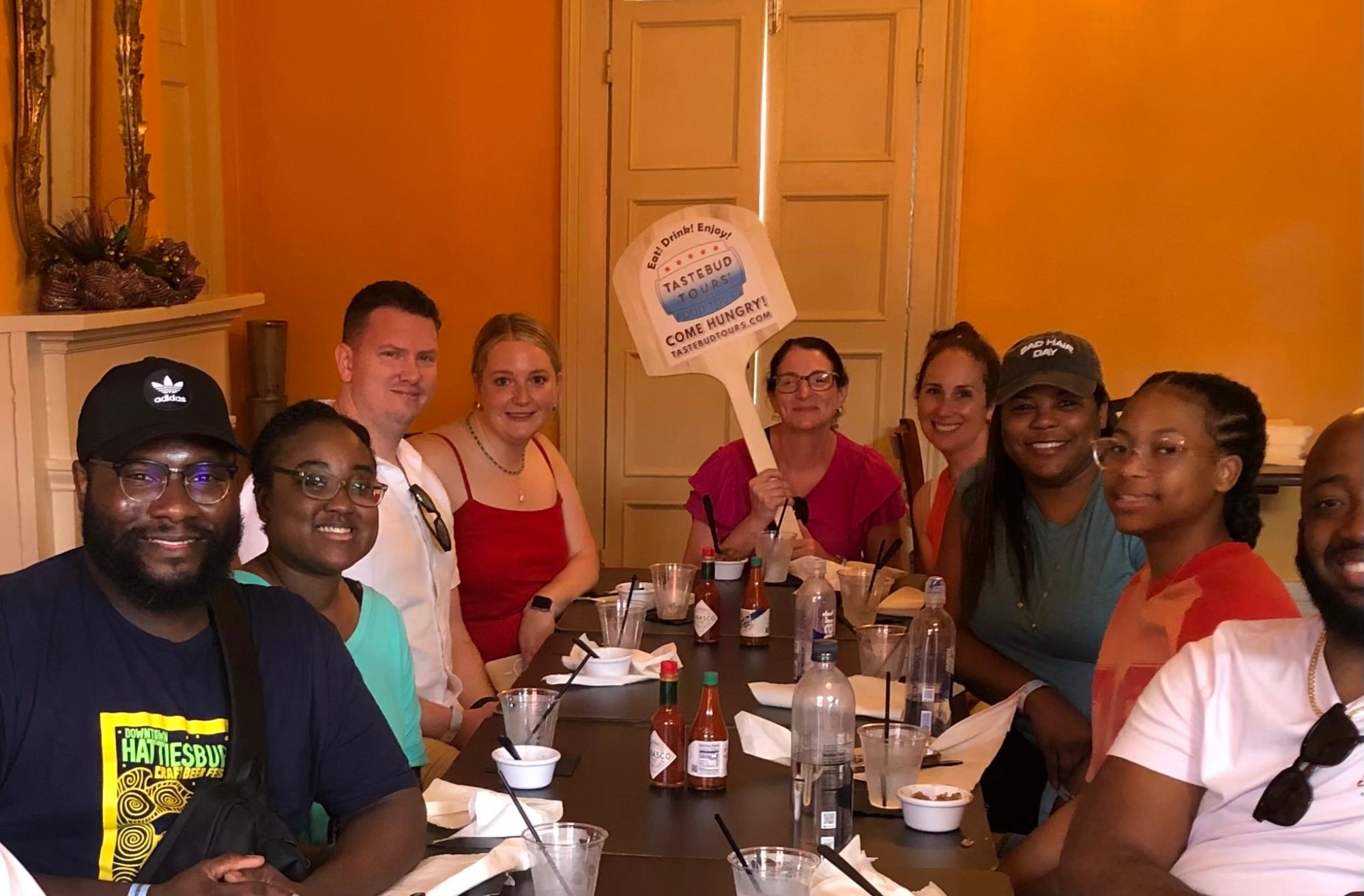 Food tour group smiling around a restaurant table.