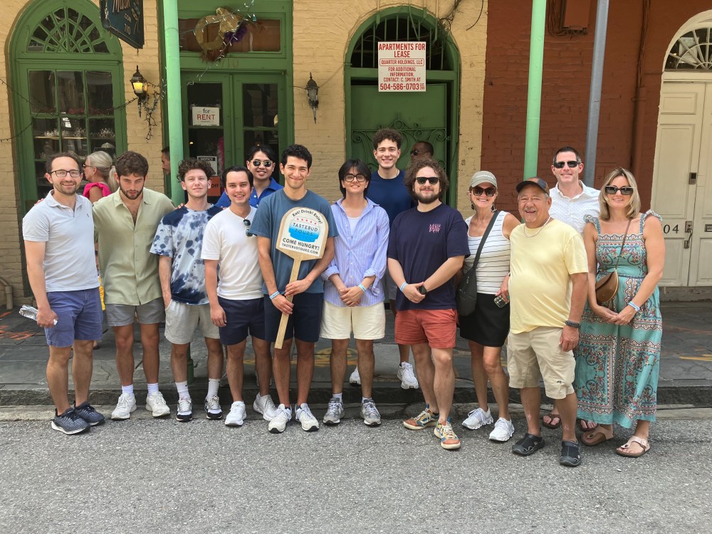Group of visitors enjoying a Tastebud Tours walking food experience in New Orleans.