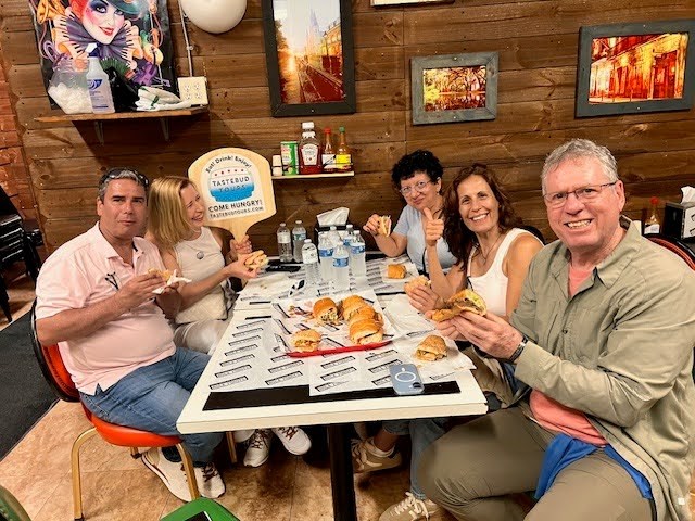 Guests enjoying a New Orleans food tour experience with local dishes at a restaurant table.
