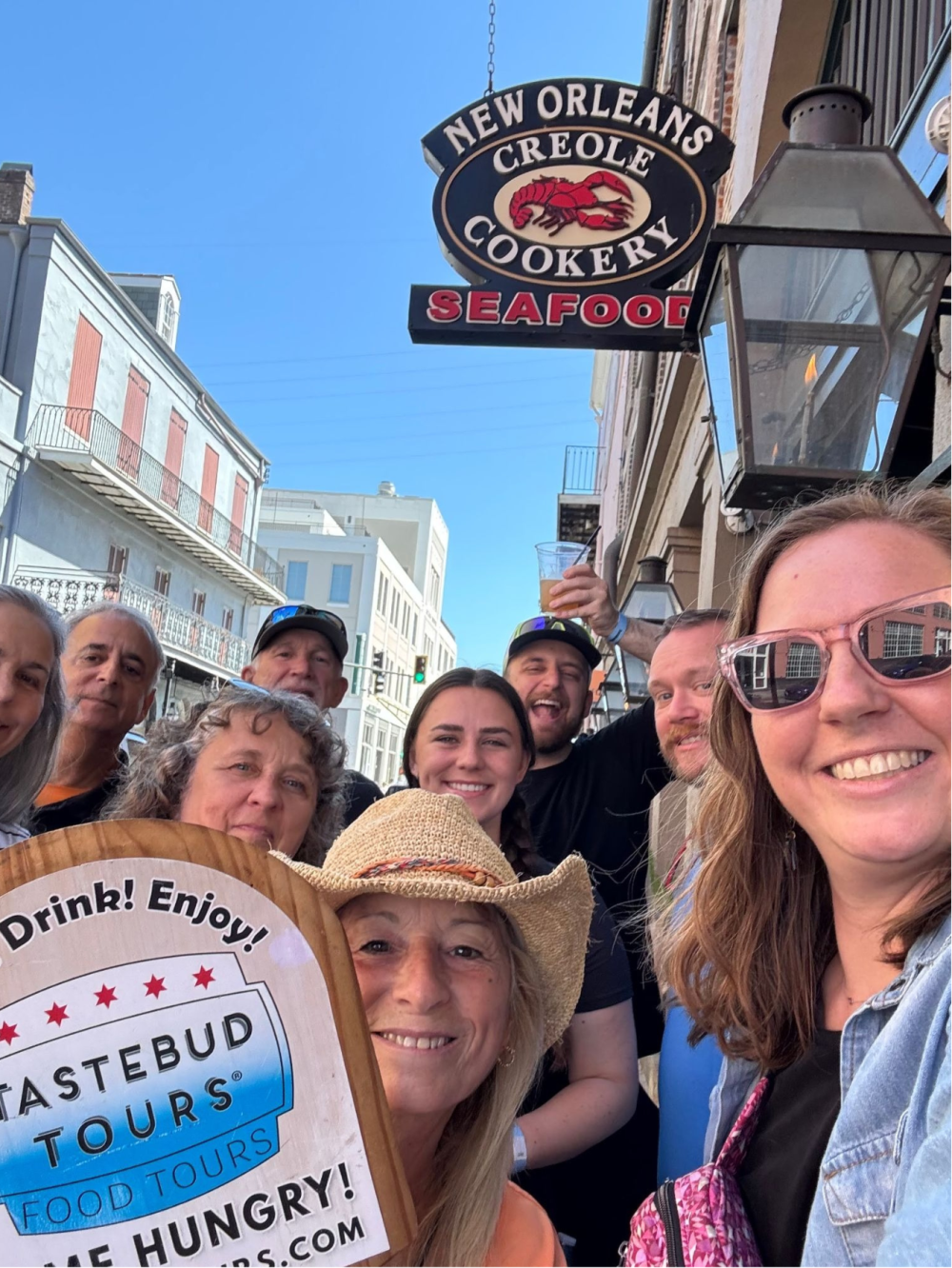 Tastebud Tours group posing outside New Orleans Creole Cookery seafood restaurant in the French Quarter.