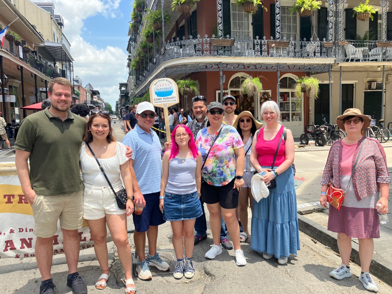 Tastebud Tours group posing on a sunny French Quarter street in New Orleans.
