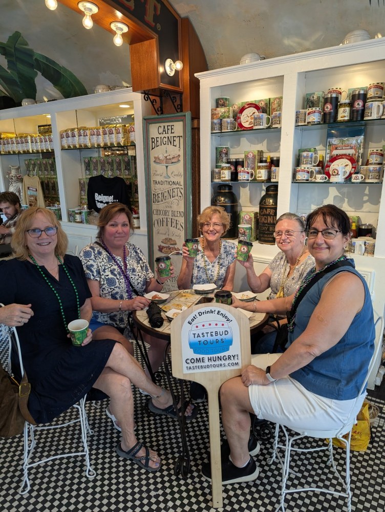 Tastebud Tours guests enjoying New Orleans coffee and beignets at Café Beignet in the French Quarter.