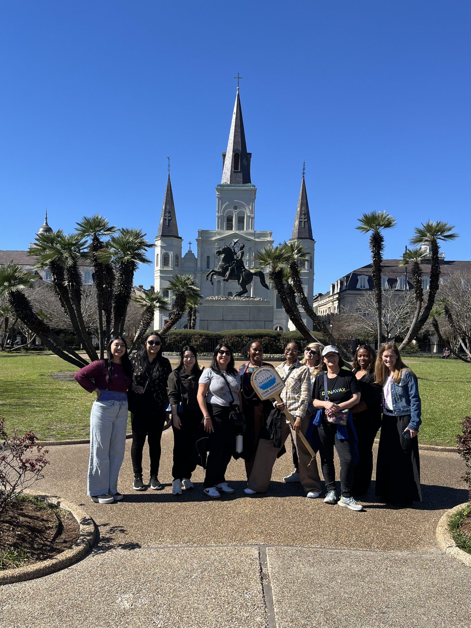Tastebud Tours group posing for a photo at Jackson Square in New Orleans, with St. Louis Cathedral in the background.
